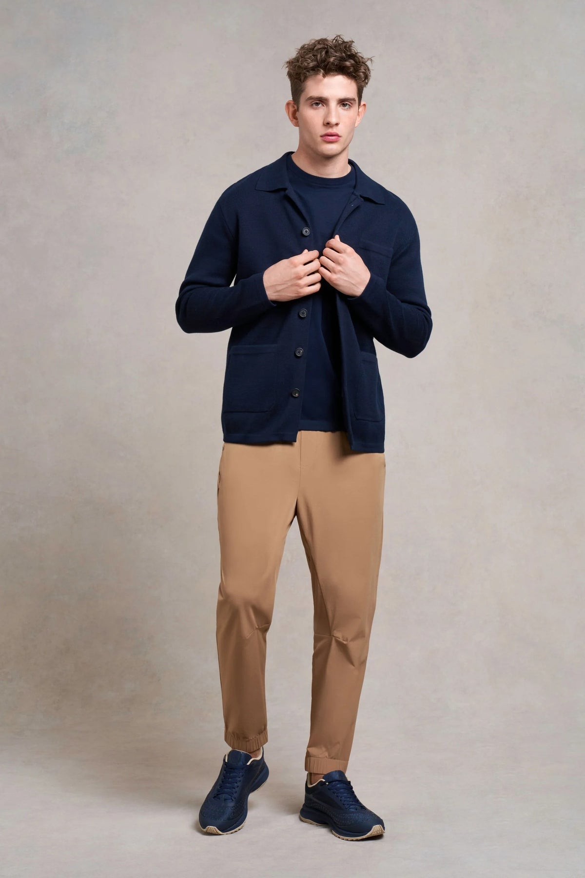 Man in a navy overshirt and tan trousers