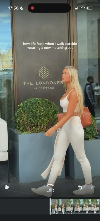 Pale sports bra and leggings styled with white trainers and a tan bag, then a zip-up jacket