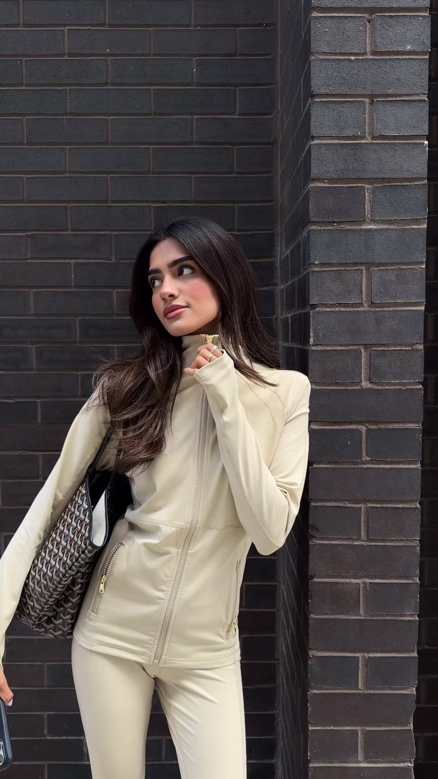 Barley zip-up jacket worn against a dark brick wall