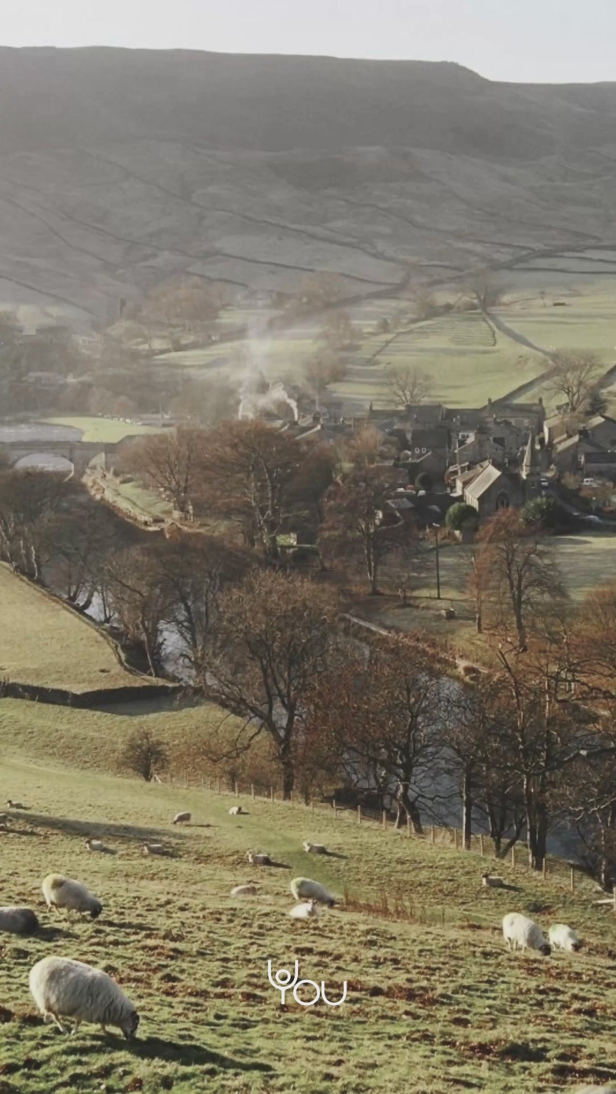 Clay: a misty valley with a village and grazing sheep
